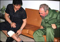 Diego Maradona shows Fidel Castro his tattoo of Castro which he wears on his leg.