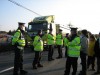 Garda stand watch over trucks moving surface peat from the site of the propesed refinery