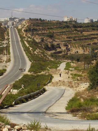 The Israeli version of 'The Road Map for Peace' - The Hebron-Halhoul road, 19 Sept 2003. The road on the left is for Israeli cars. The blocked road on the right is for Palestinians.
