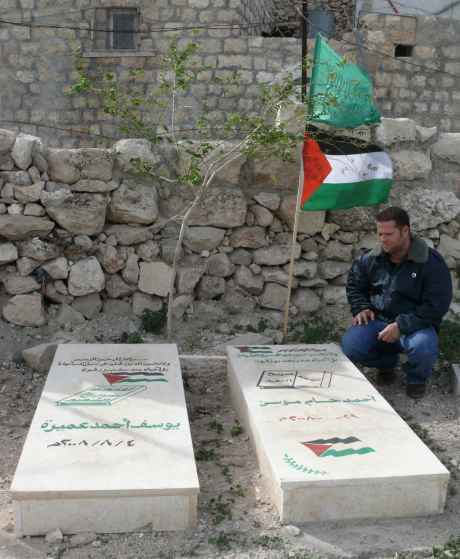 Bil'in activist, Haitham, beside graves of the murdered Ahmad Mousa and Yousef Amira in Ni'lin