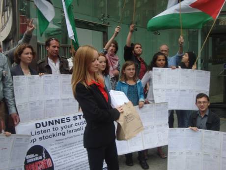 Freda Hughes IPSC Chairperson holding 6,000 signatures calling on Dunnes to stop stocking Israeli produce