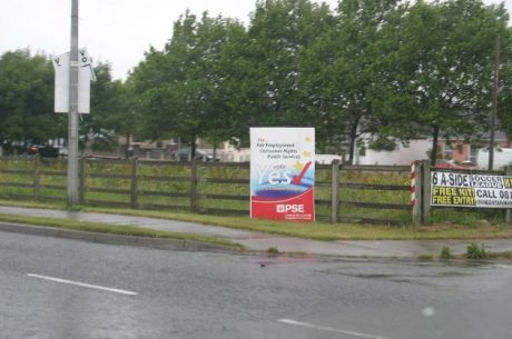 Sign adjacent to roundabout on green area. Obstructing grass cuting with no permission but not removed by City Council