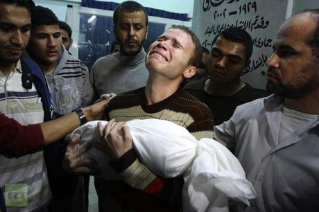 BBC correspondent Jihad Masharawi weeps as he cradles his 11-month-old son in his arms after he was burned alive during an Israeli rocket attack.