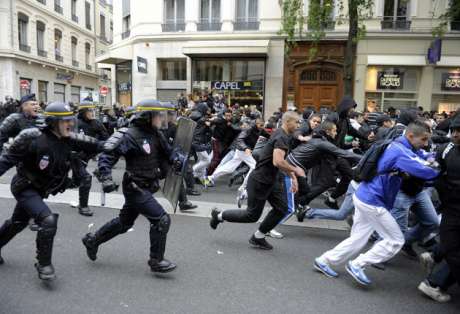 Protesters run during clashes in Lyon