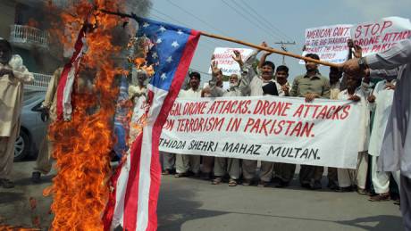 Pakistani protesters belonging to United Citizen Action march behind a burning US flag during a protest in Multan on September 30, 2013, against the US drone attacks in Pakistani tribal areas (AFP Photo / S.S Mirza)
